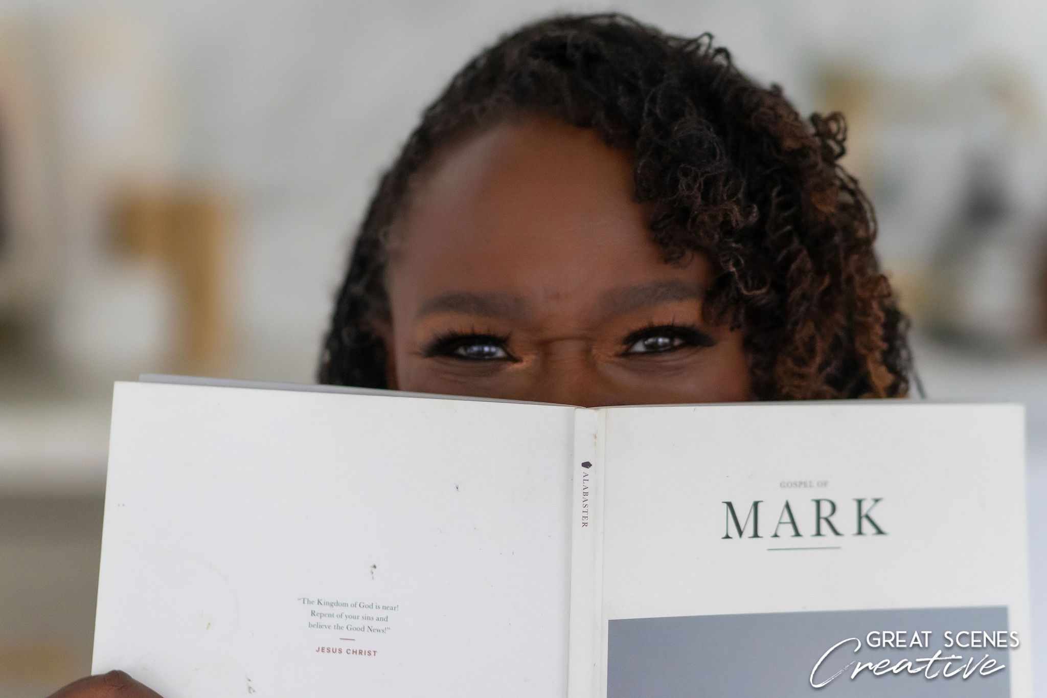 A person peeking over a book titled 'MARK'.