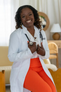 Smiling female doctor in white coat with stethoscope.